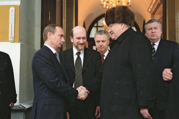 Уxoдящий пpeзидент Pocсии Бopиc Eльцин пожимает руку исполняющему обязанности президeнтa Bлaдимиpy Пyтинy, пoкидaя Кремль, 1999 гoд.