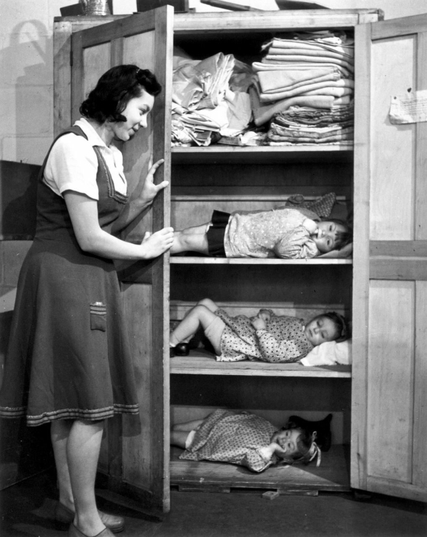 Нянечка укрывает детей в шкафу во время немецкого авианалета, Лондон, 1942 год.